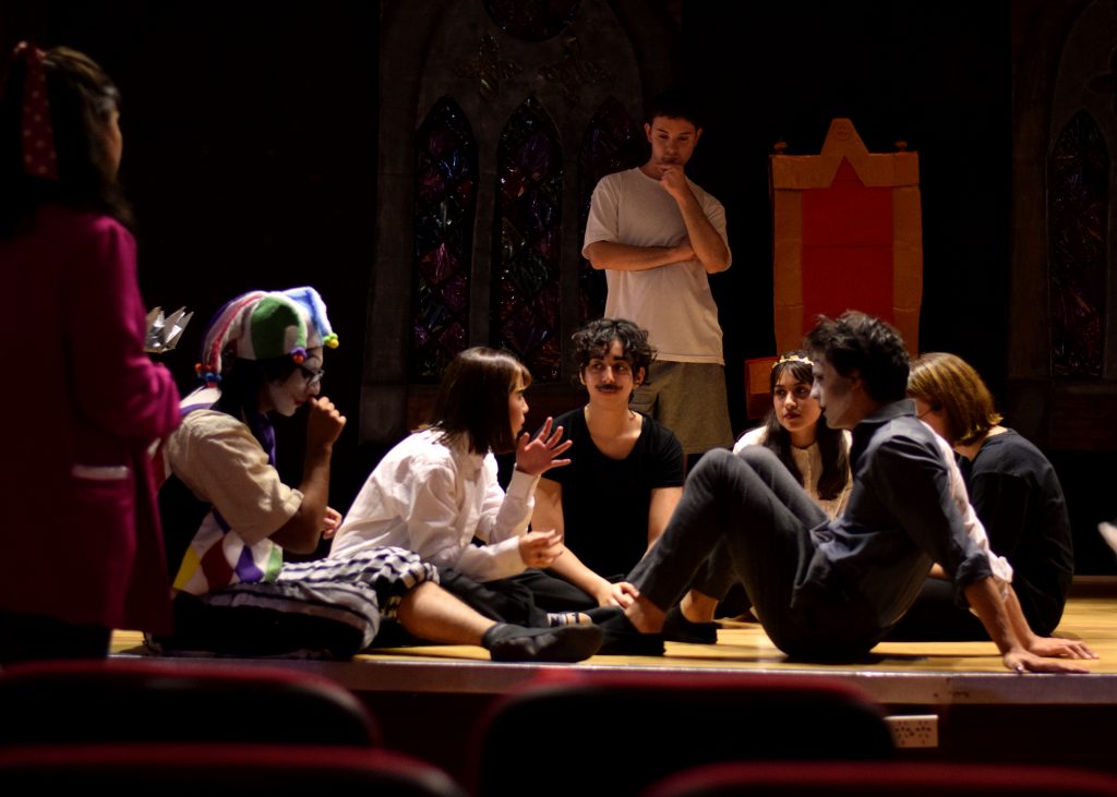 Ensayo de la Obra Hamlet del Grupo del Teatro Estable de Humanidades. Sentadas en ronda hay seis personas charlando. Junto a ellas otras dos personas paradas mirando al grupo